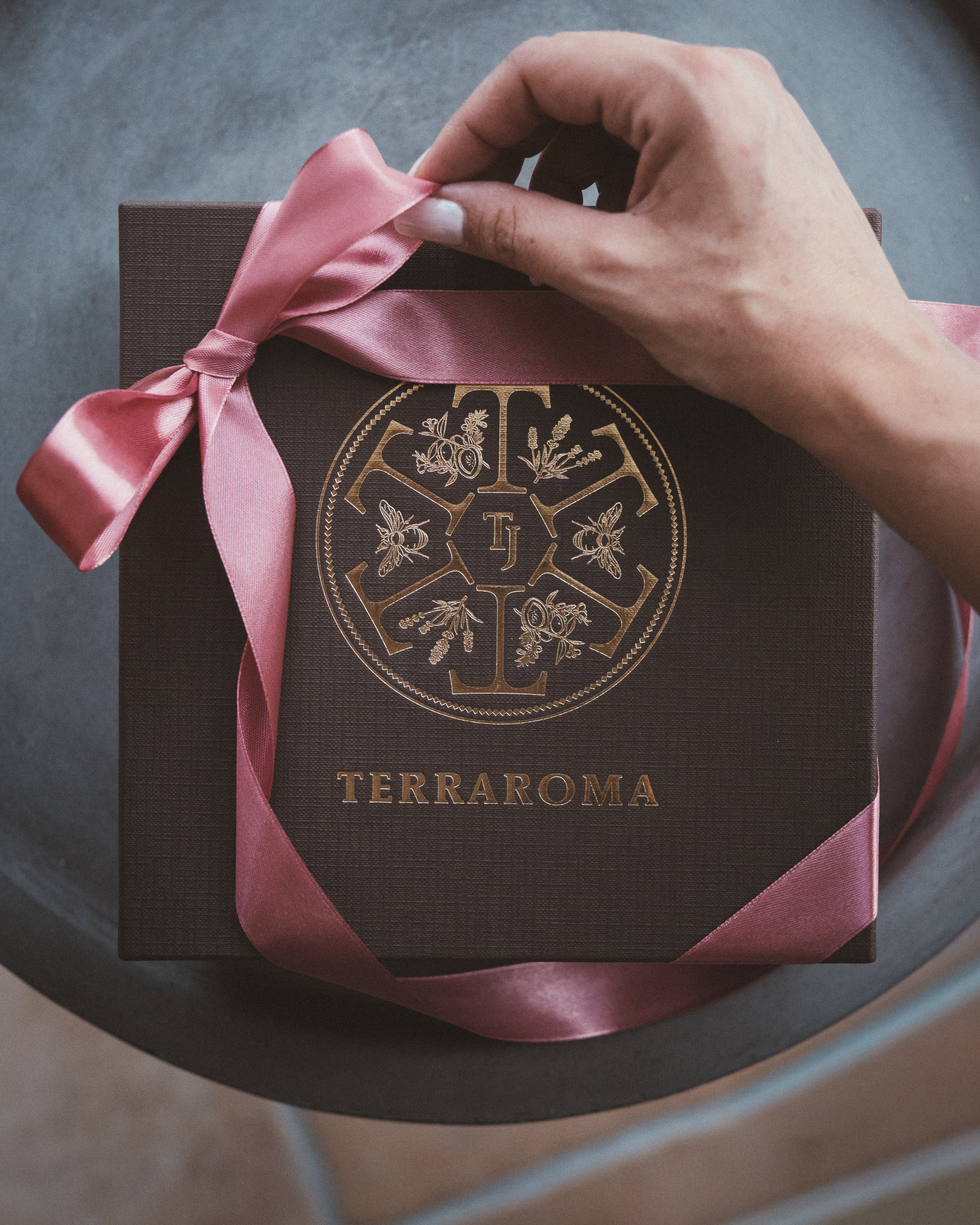 Une boite cadeau Terraroma fermée par un joli ruban rose poudré