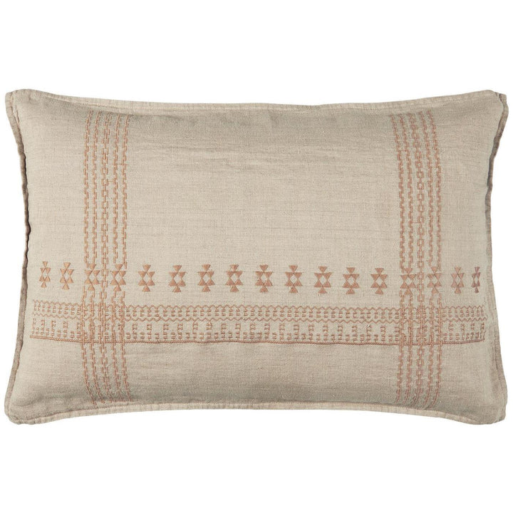 Un coussin rectangulaire en tissu beige clair avec des broderies géométriques dans des tons de terre cuite. Les motifs, inspirés d’un style artisanal, se répètent horizontalement au centre et verticalement aux extrémités, donnant un aspect délicatement travaillé au coussin.